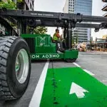 Thumbnail of ω澳门威斯人平台首页 Machinery moving crew driving green lift in downtown Seattle.